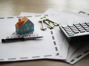 Insurance policy documents with house model and calculator