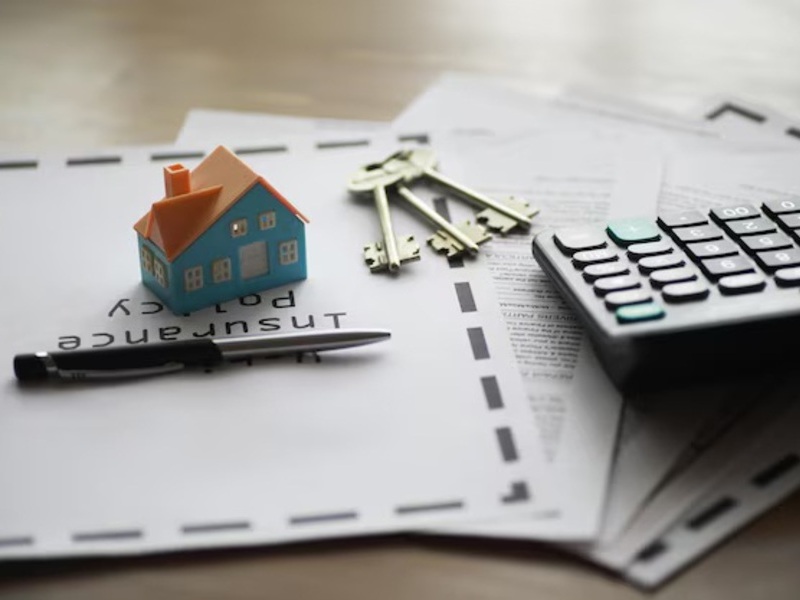 Insurance policy documents with house model and calculator