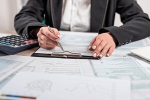 Reviewing deductible details on a business insurance policy with calculator and documents