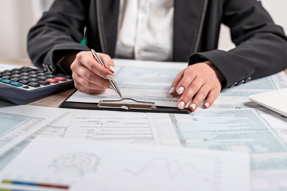 Reviewing deductible details on a business insurance policy with calculator and documents