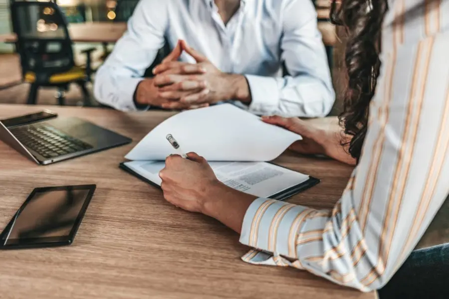 Business owners reviewing contract documents and additional insured insurance requirements