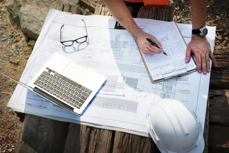 Contractor reviewing construction project documents for OCIP insurance cost planning