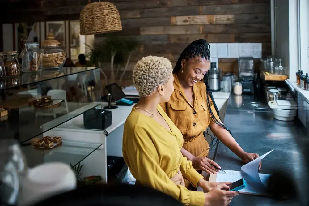 Restaurant owners reviewing business insurance documents in a cafe