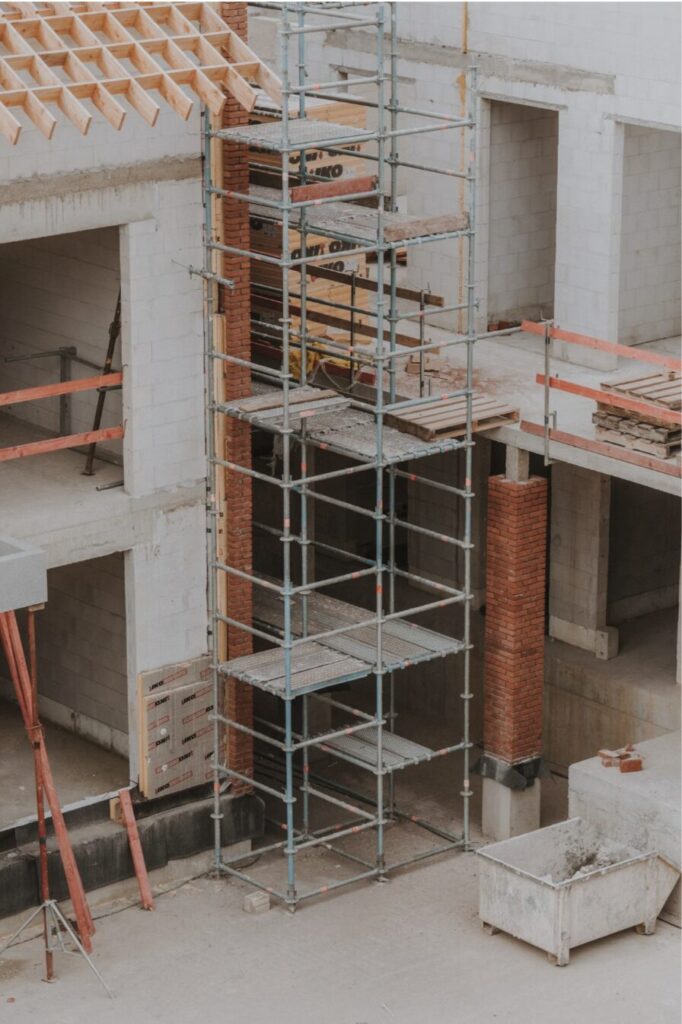 Building under construction with scaffolding and exposed materials not yet weathertight, representing risks covered by builders risk insurance.
