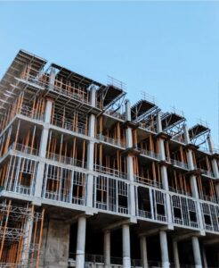 Multi-story building under construction with exposed steel and concrete framing, representing California builders risk insurance coverage during active construction.