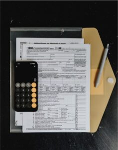 Insurance forms and a calculator on a desk, representing a contractor insurance compliance checklist.