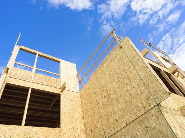 Wood-frame multifamily condominium building under construction, low angle view, representing the OCIP wrap-up insurance case study project.