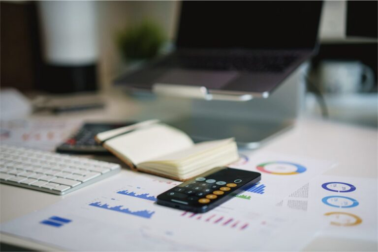 Financial charts and a calculator on a desk, representing the wrap-up insurance feasibility scoring calculator.