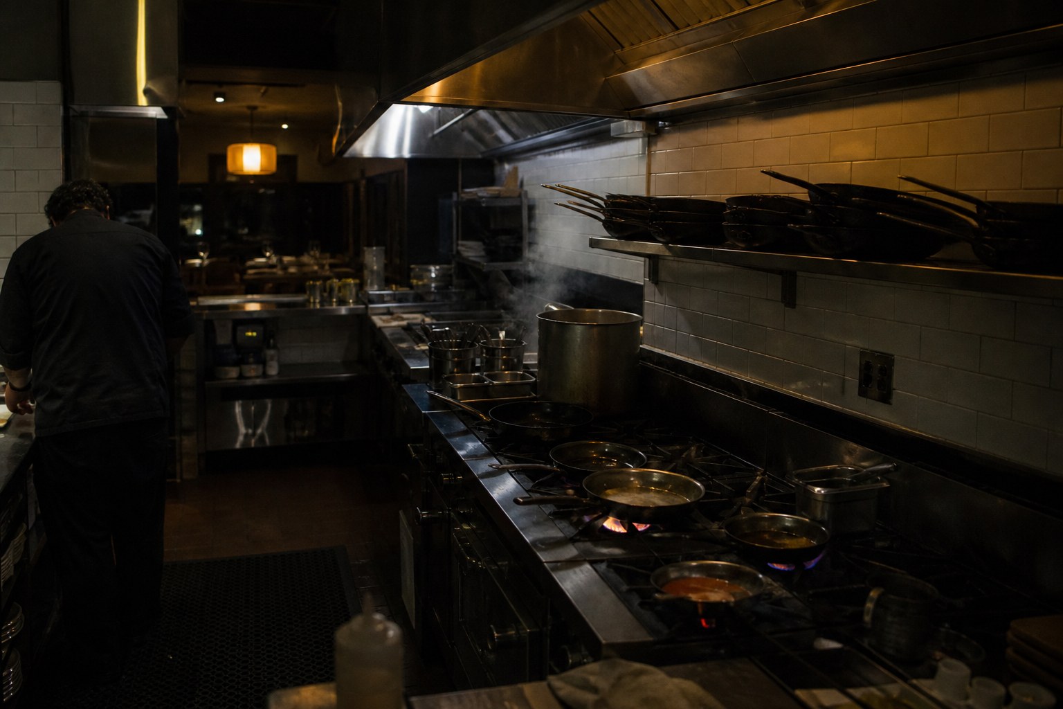Commercial kitchen at night, cook working the line